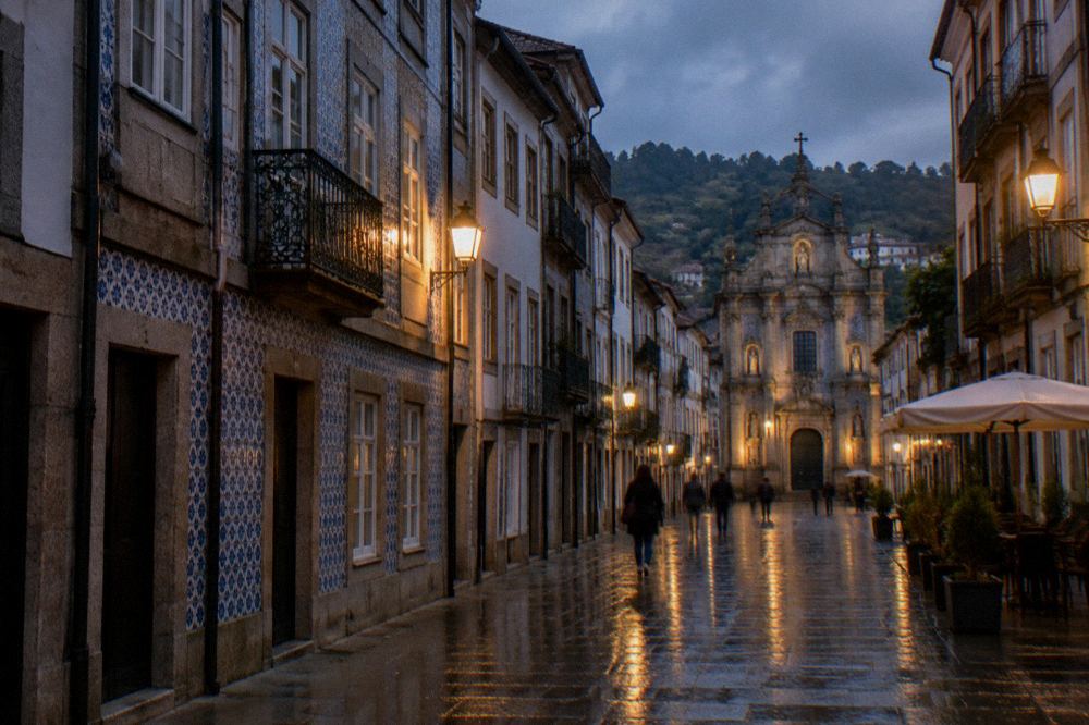 Wet cobblestones reflecting street lights on an evening street in Braga after rain