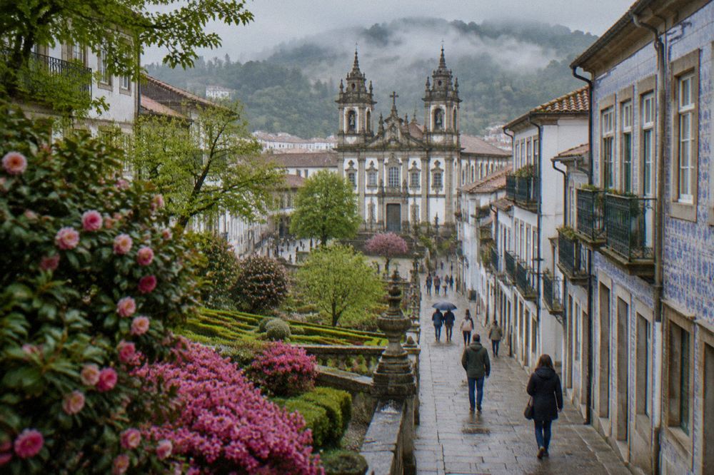 Spring flowers blooming in a formal garden with a baroque church behind them in Braga