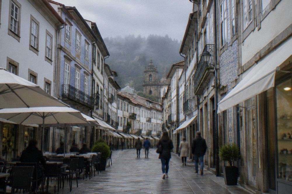 A pedestrian shopping street in central Braga with café tables and people strolling on flat paving