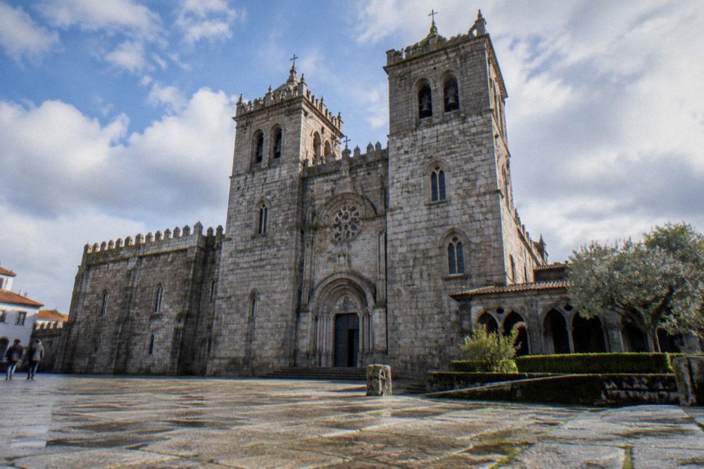 The granite exterior and twin towers of Braga cathedral seen from a level square