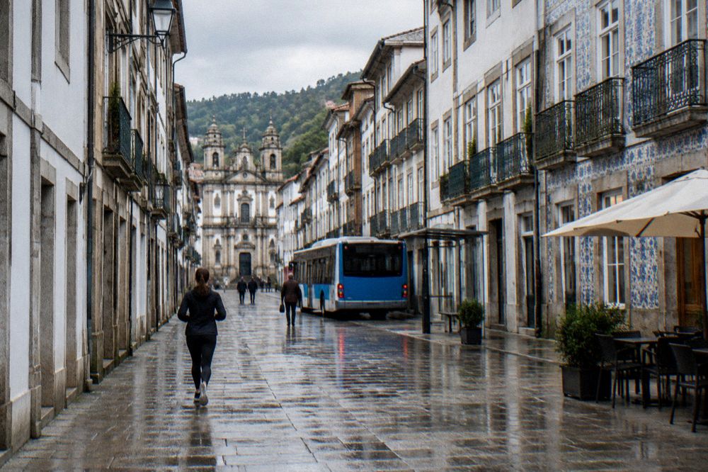 A blue and white city bus stopped at a street stop in central Braga