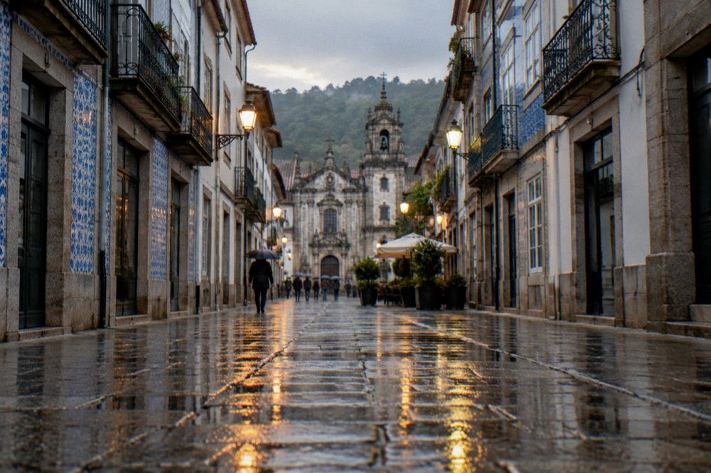 Wet polished cobblestones in a Braga street reflecting streetlights after rain