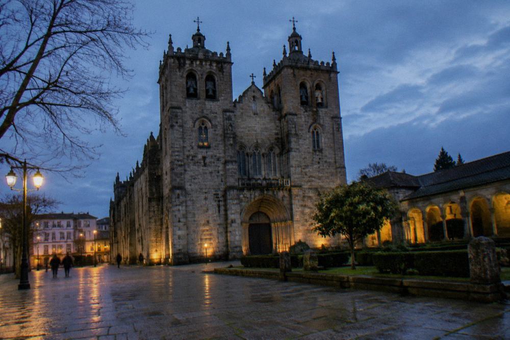 The twin-towered facade of Braga Cathedral seen from the square at night
