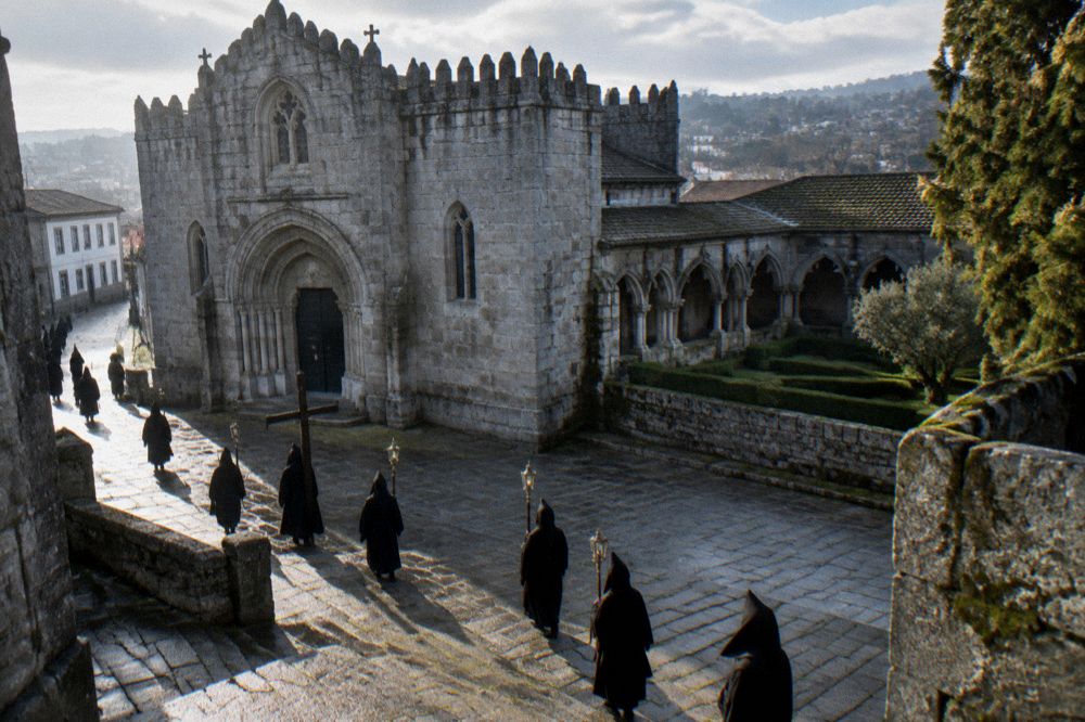 A procession of hooded figures walking through Braga's streets during Holy Week