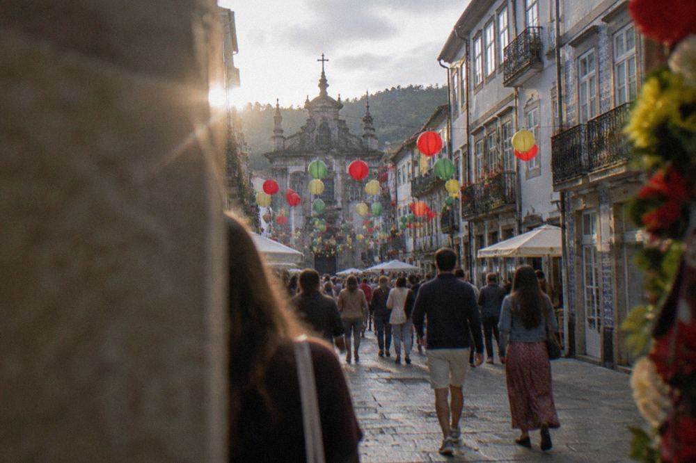 Decorated street with paper lanterns and crowds celebrating São João in Braga