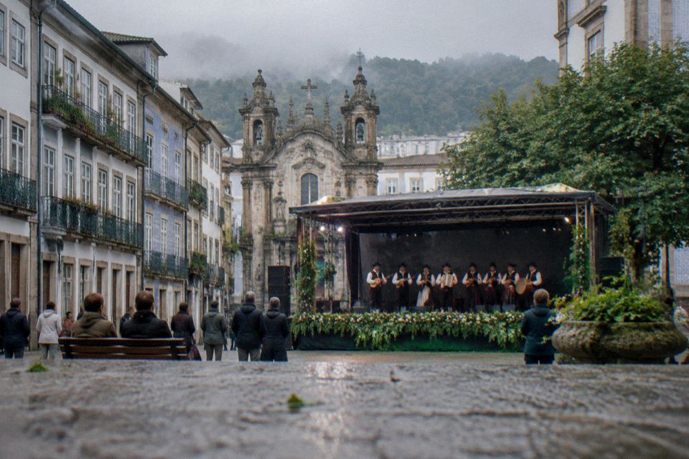 A band playing traditional music on a decorated stage in a Braga square
