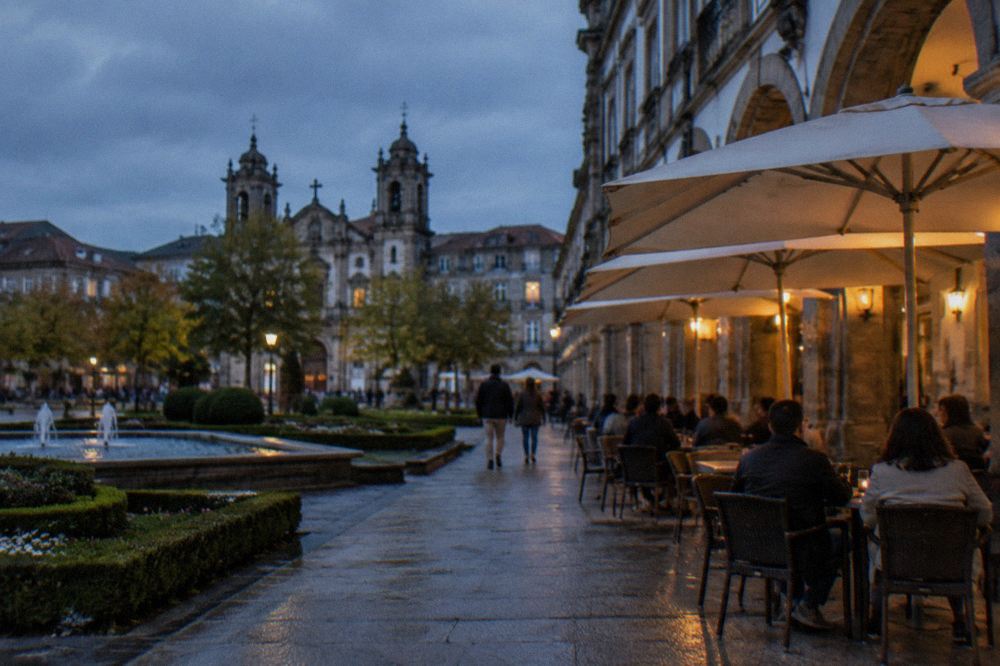 Café terrace with warm lights and people at tables on a pedestrian street in the evening