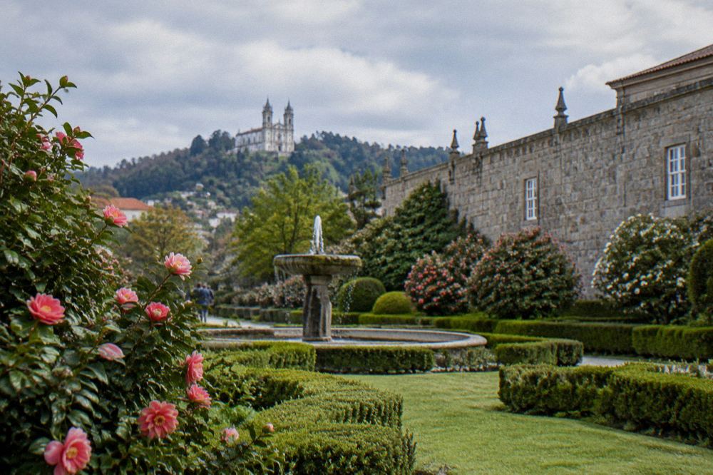 A white basilica with twin towers standing on a hilltop above rolling green countryside