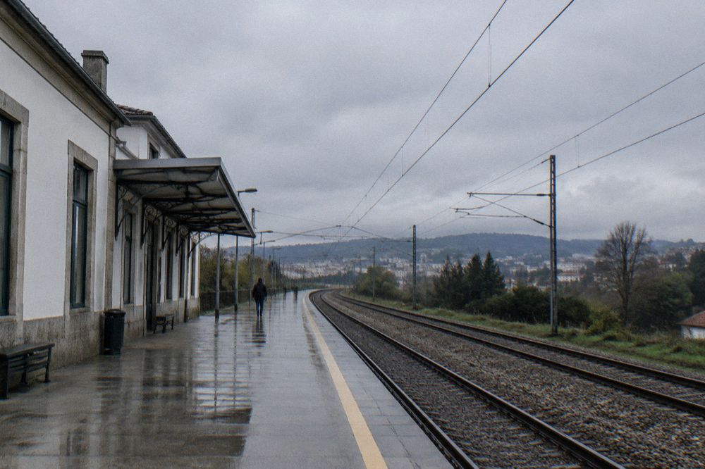 Railway tracks curving through countryside towards a town on the horizon