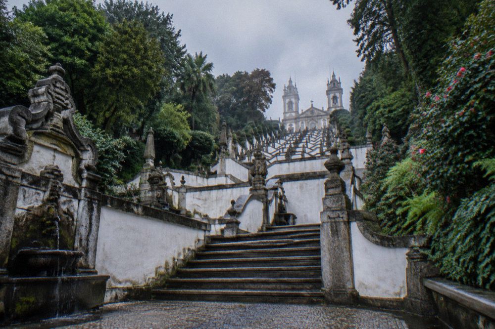 The zigzag stone stairway of Bom Jesus do Monte seen from below, with fountains and statues along the flights