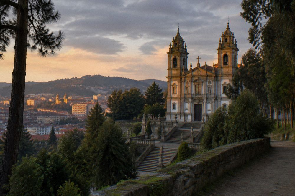 Golden evening light on Braga's rooftops and church towers seen from a hillside path