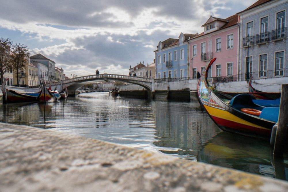 A canal bridge and pastel façades in Aveiro at midday