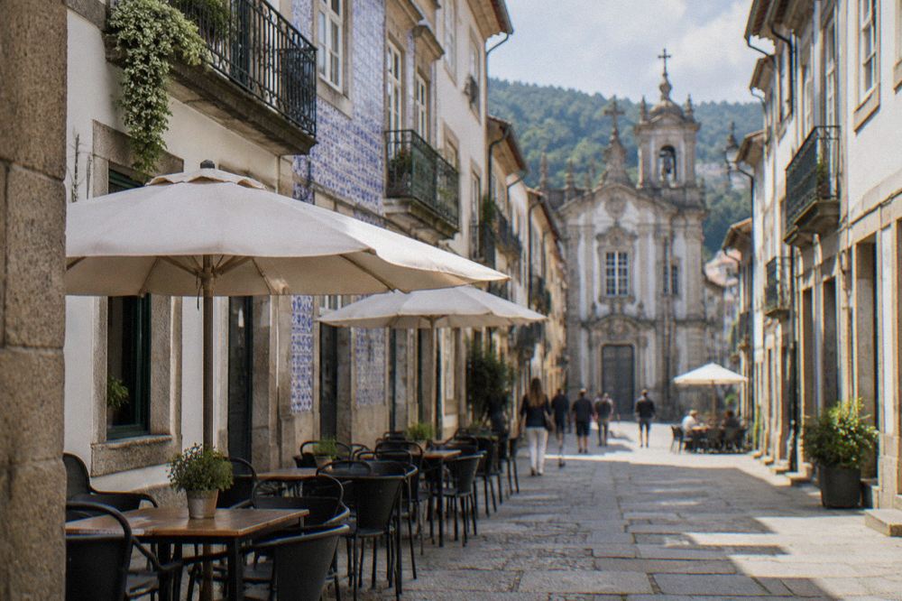 Narrow granite street with café tables in Braga's historic centre on a sunny afternoon