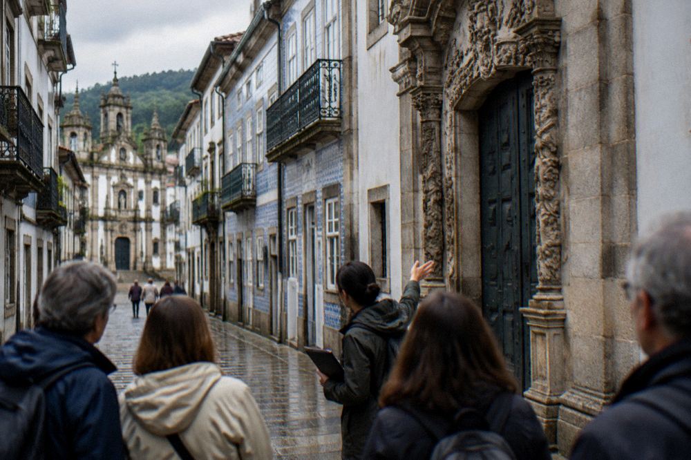 A guide showing a small group of visitors a carved stone portal in central Braga