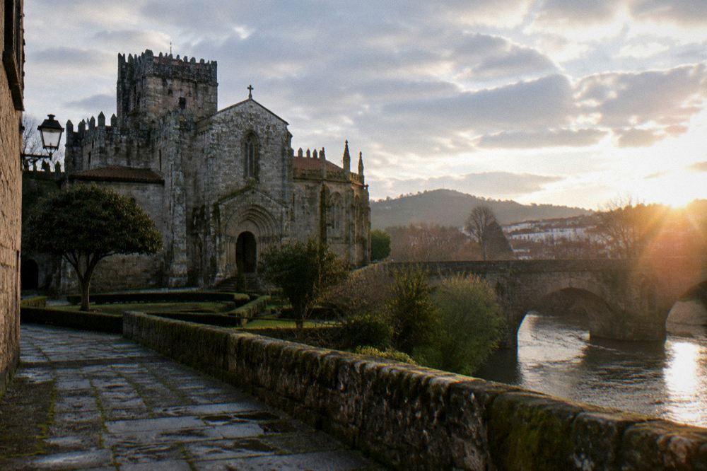 A medieval stone bridge over a river in a green northern Portuguese town