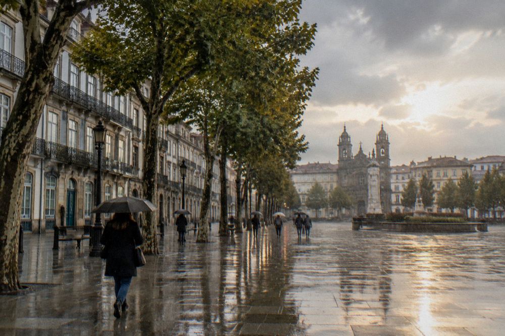 Rain falling on a cobbled square with historic buildings and wet paving stones