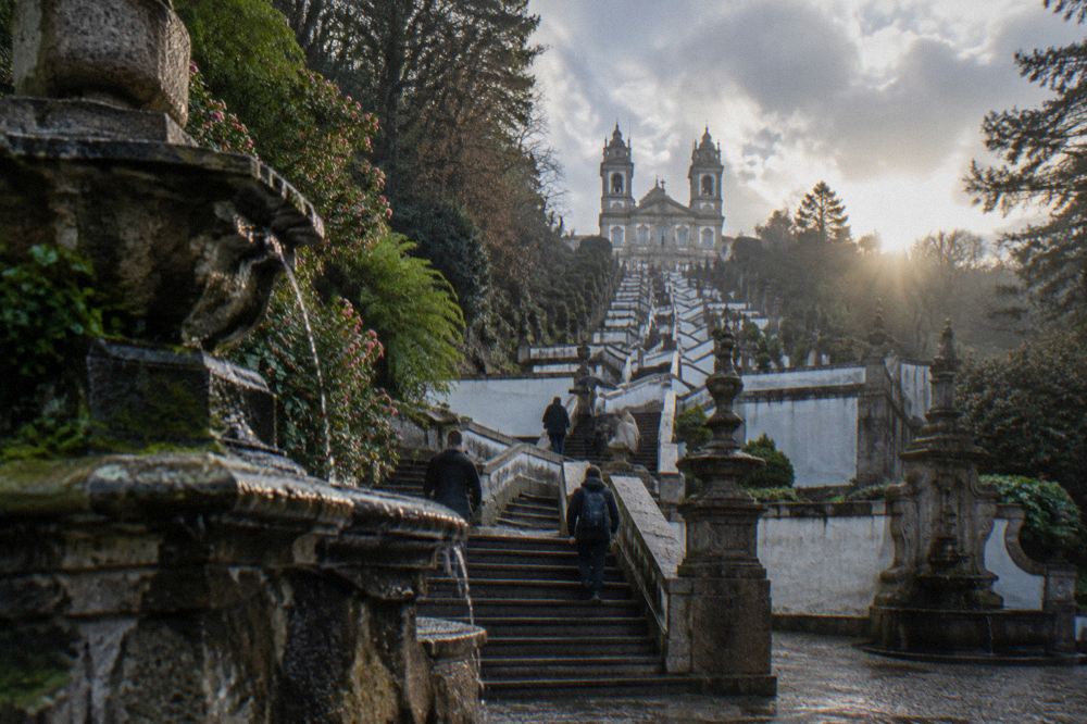 Visitors walking the stone stairway of Bom Jesus do Monte between the decorative fountains