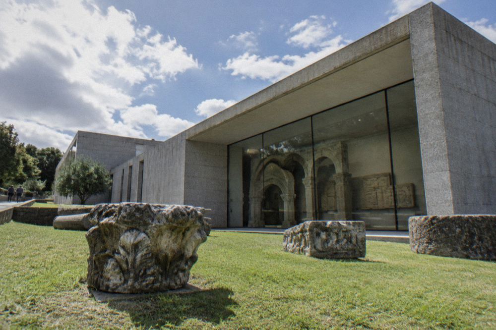 Stone arches and Roman carved reliefs inside an archaeology museum gallery in Braga