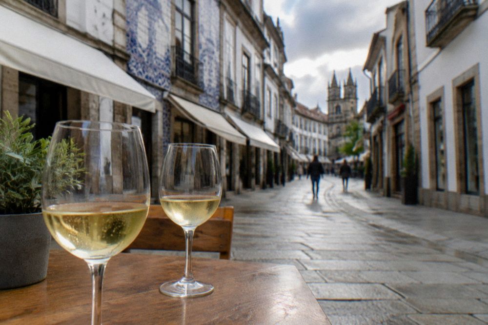 Two glasses of pale slightly sparkling white wine on a wooden table in a wine estate tasting room