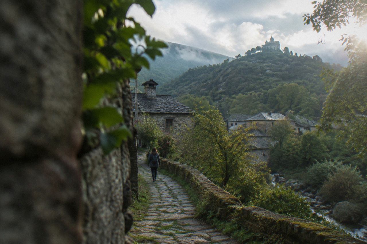 A stone path climbing through green woodland toward a hilltop sanctuary above Braga