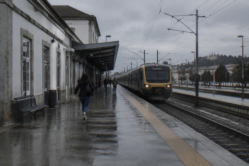 A long-distance train waiting at a platform in a Portuguese railway station