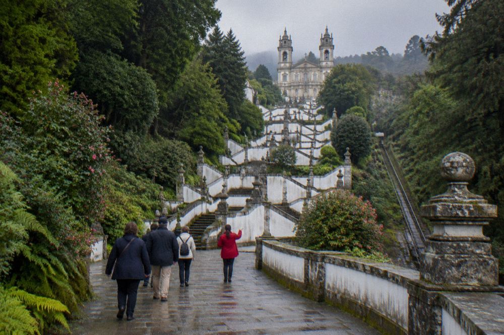 A guide leading a small group of visitors along a terrace at the Bom Jesus sanctuary