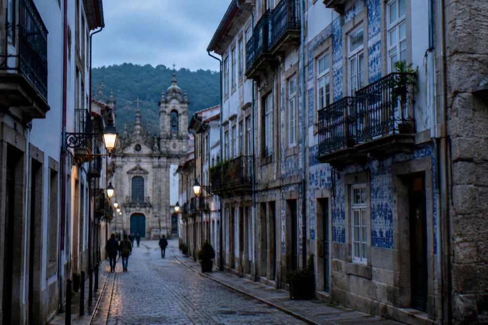 A narrow cobbled street in a Portuguese historic centre with baroque building facades