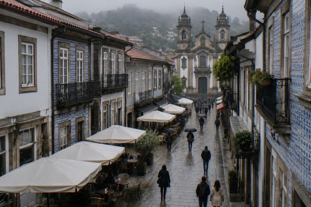 A pedestrian street in Braga with cafe terraces and shoppers in the late afternoon
