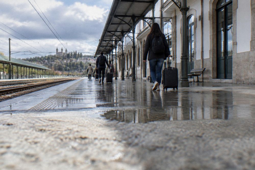 Travellers walking through an airport arrivals hall with their luggage