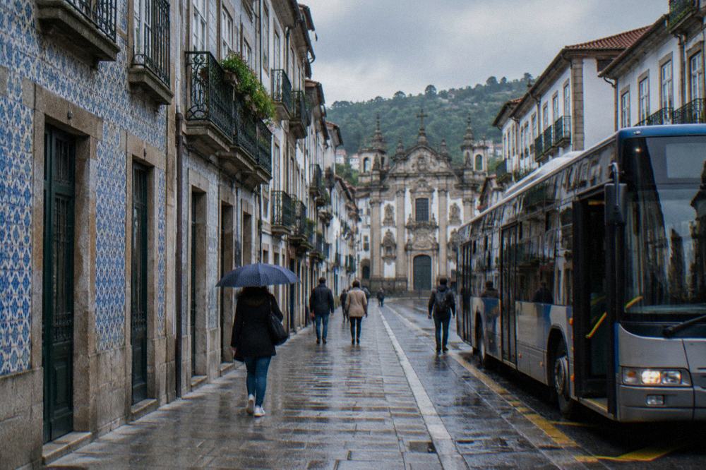 A city bus stopped at a marked stop on a Braga avenue