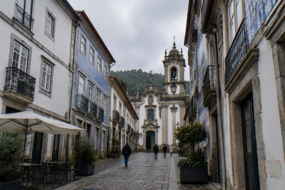 A cobbled square in a Portuguese historic centre with baroque church facades