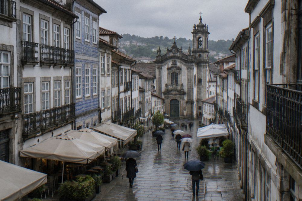 Rain-slicked cobblestones in central Braga with umbrellas and cafe awnings