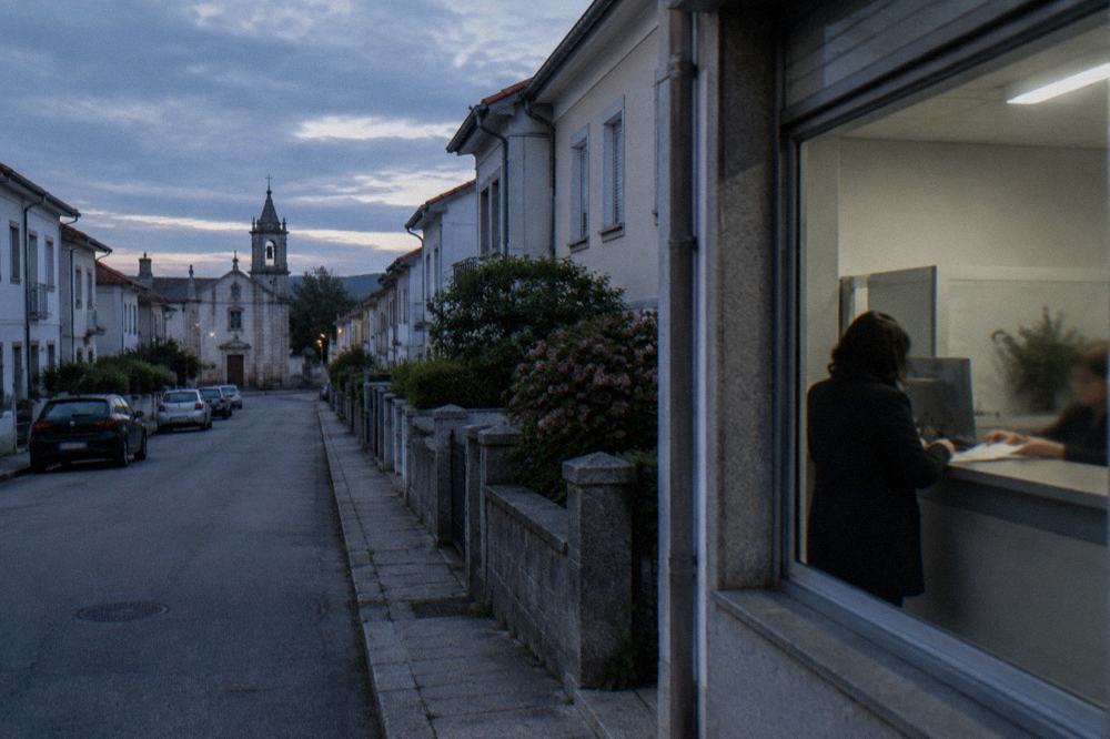 A Portuguese administrative office counter with a person handing over documents
