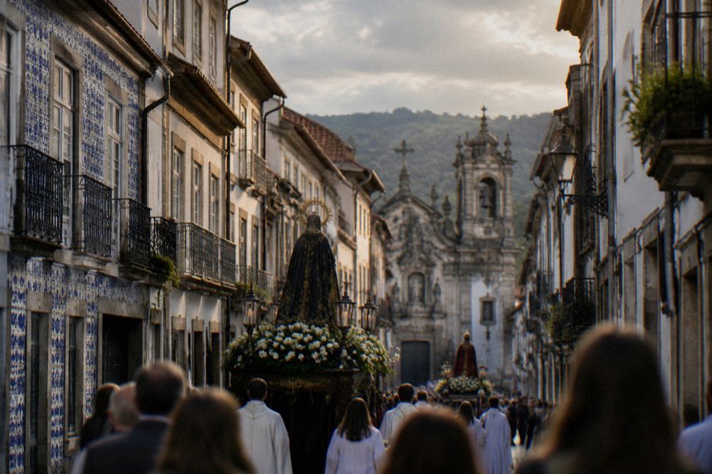 A festival procession with decorated floats moving through a narrow street of old buildings