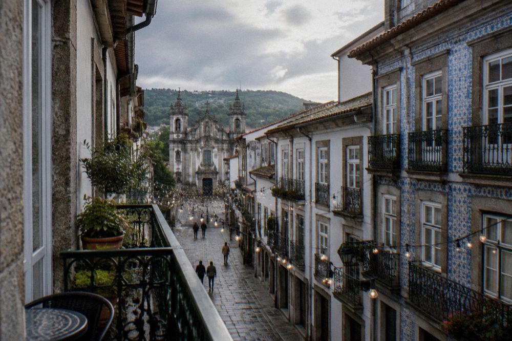 A hotel guesthouse balcony overlooking festive lights strung across a narrow street