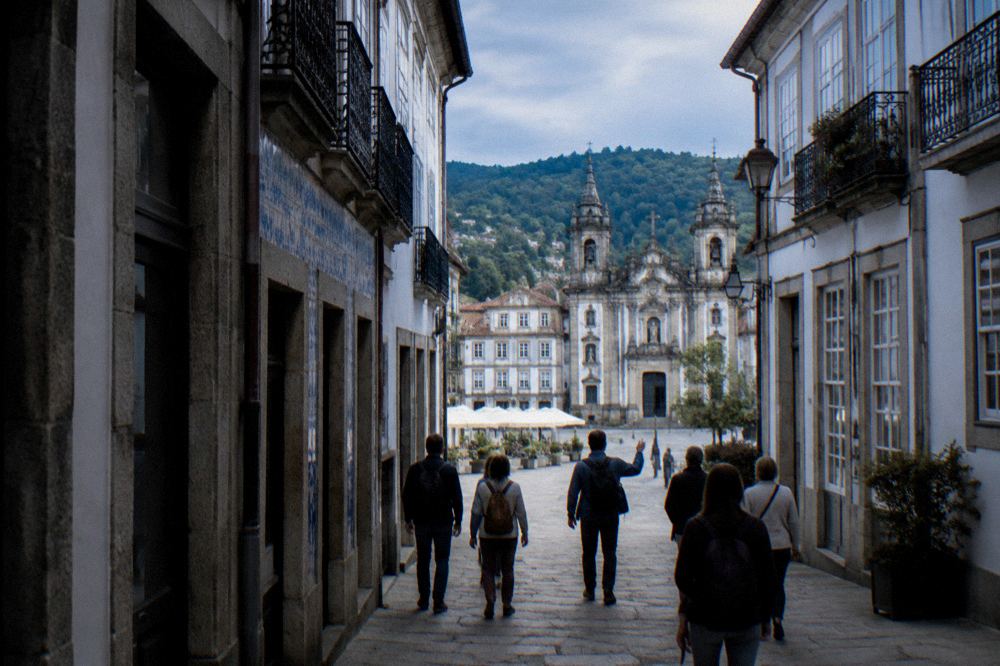 A small group of visitors walking with a guide through a sunlit Braga square
