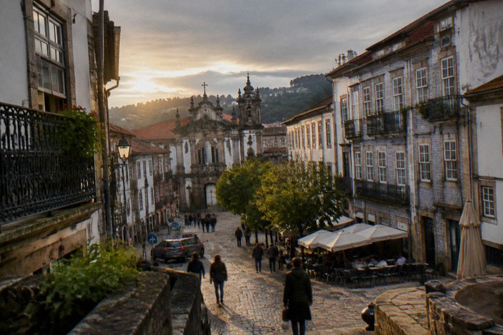 A cobbled square in Braga with café tables outside historic buildings
