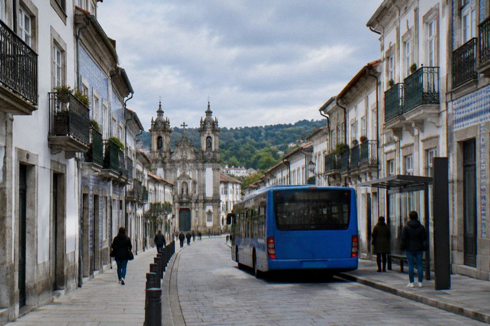Blue city bus stopped at a TUB bus stop on a street in Braga