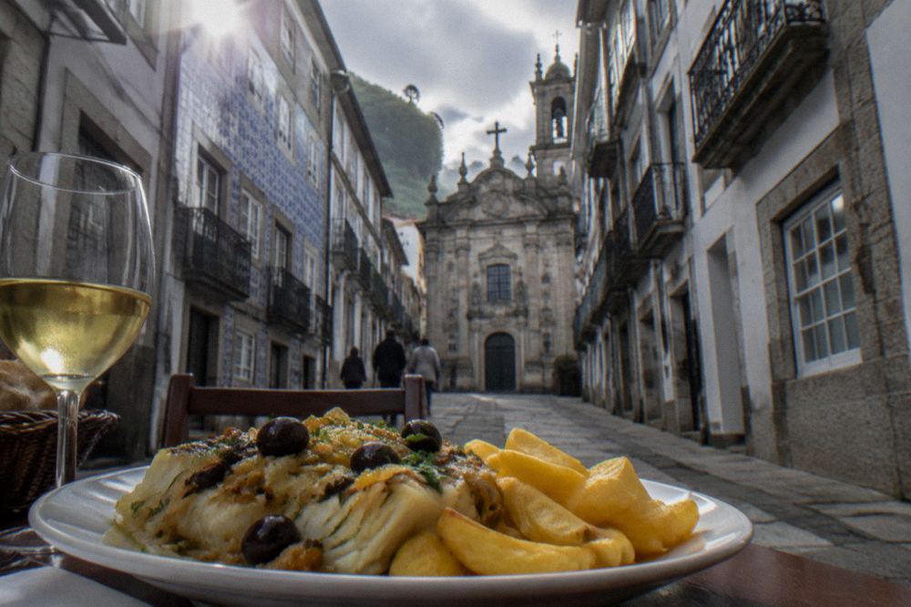 A plate of bacalhau à Braga with crisp fried potatoes served in a restaurant