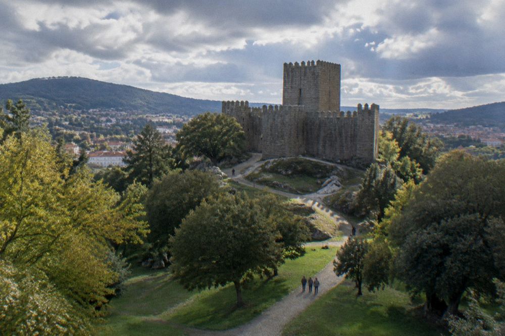 The medieval castle of Guimarães with its square keep seen from the surrounding parkland