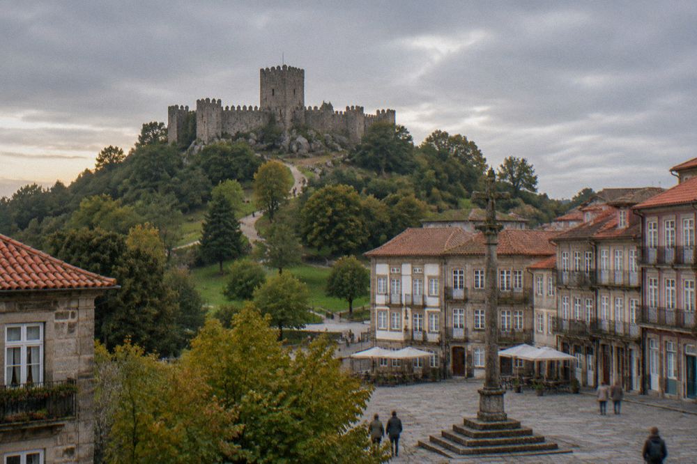 The Largo da Oliveira square in Guimarães with its stone cross and historic townhouses at golden hour