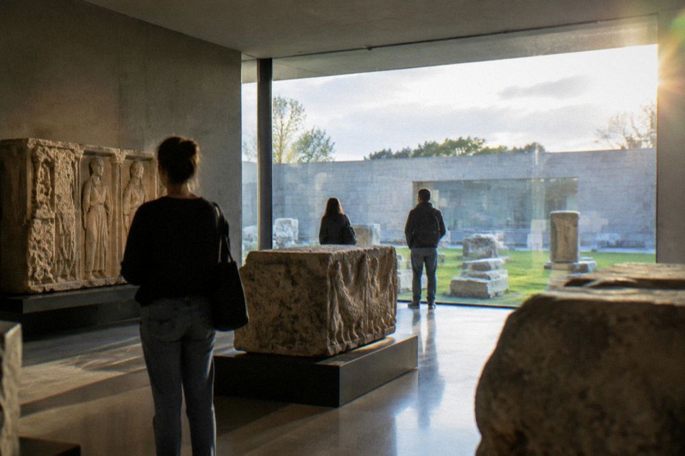 Visitors looking at stone Roman carvings inside the archaeology museum in Braga