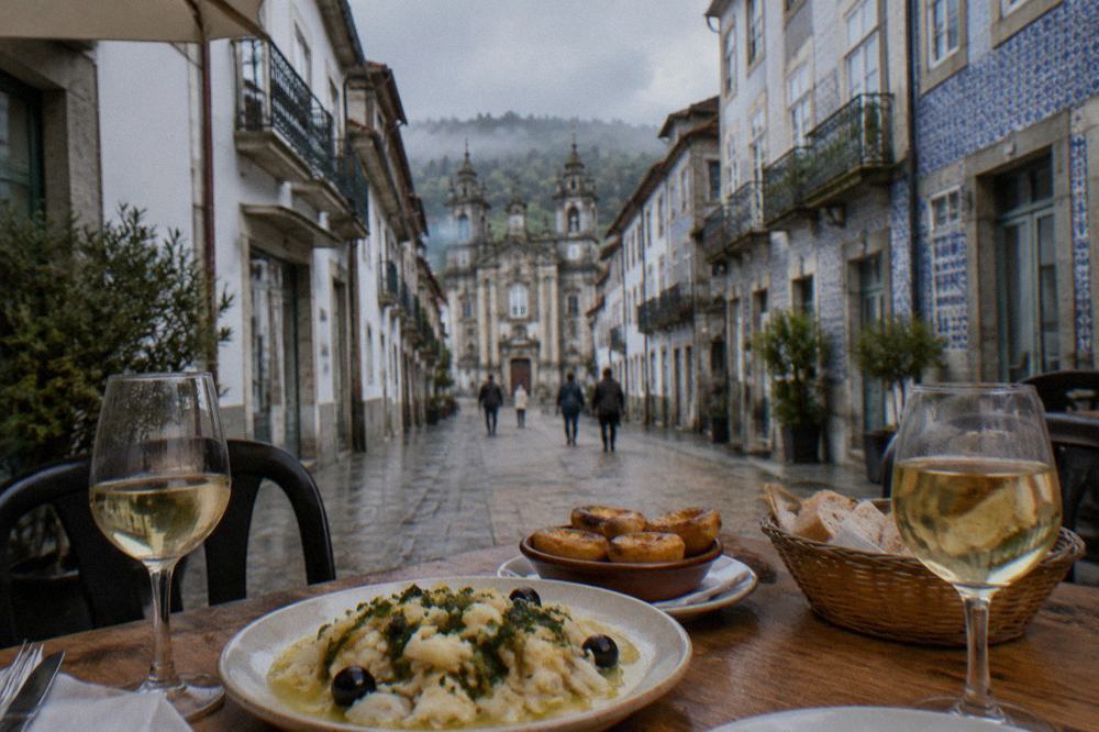 A table with salt cod, pastries and glasses of vinho verde in a Braga restaurant