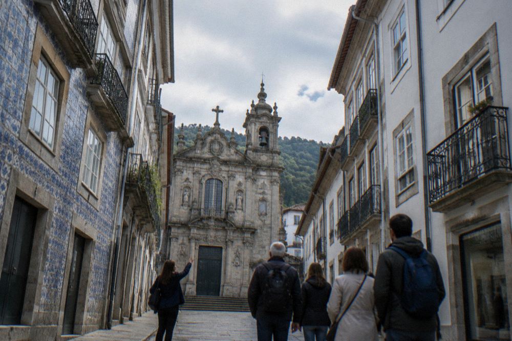 A guide showing a small group the carved facade of a church in Braga
